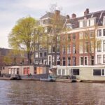 Noclegi w Holandii: houseboats, farmy i nietypowe miejsca na sen blisko natury i atrakcji Kanał w Amsterdamie z houseboatami i historycznymi kamienicami