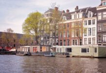 Kanał w Amsterdamie z houseboatami i historycznymi kamienicami