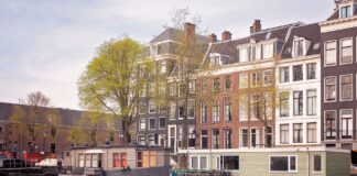Kanał w Amsterdamie z houseboatami i historycznymi kamienicami