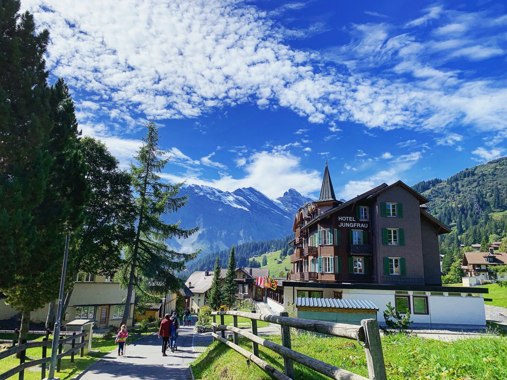 Lauterbrunnen latem z hotelem Jungfrau na tle gór i błękitnego nieba