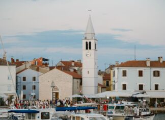 Chorwacki port o zmierzchu z wieżą zegarową i łodziami